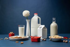 Plain bottles and a carton of plant milk on a blue table — photo by cottonbro studio on Pexels