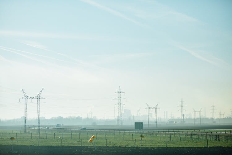 A Foggy Field With Electric Towers