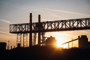 Industrial gantry silhouetted at sunset — photo by Bence Szemerey on Pexels