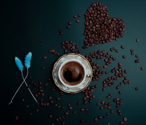 Coffee in a Decorative Cup Among Coffee Beans