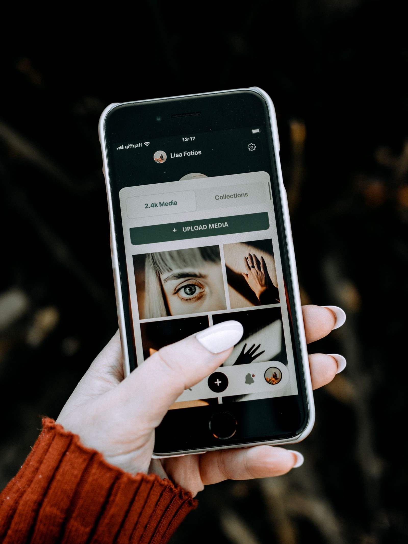 Person holding a smartphone displaying a photo gallery, the moment before an image gets uploaded and its metadata locked into the file Flickr stores