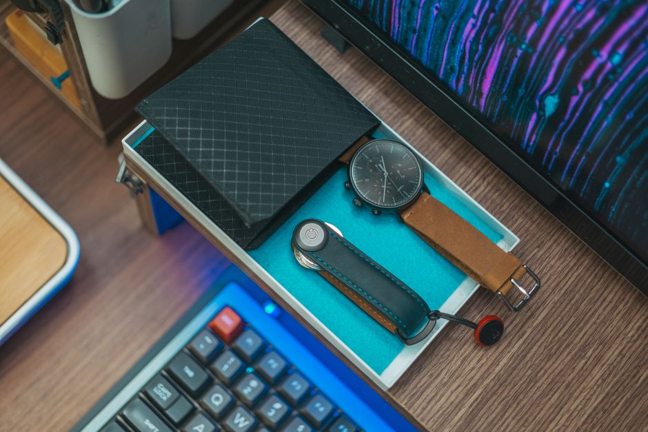 A stylish desktop setup featuring a watch, wallet, and keyboard, ideal for modern workspaces.