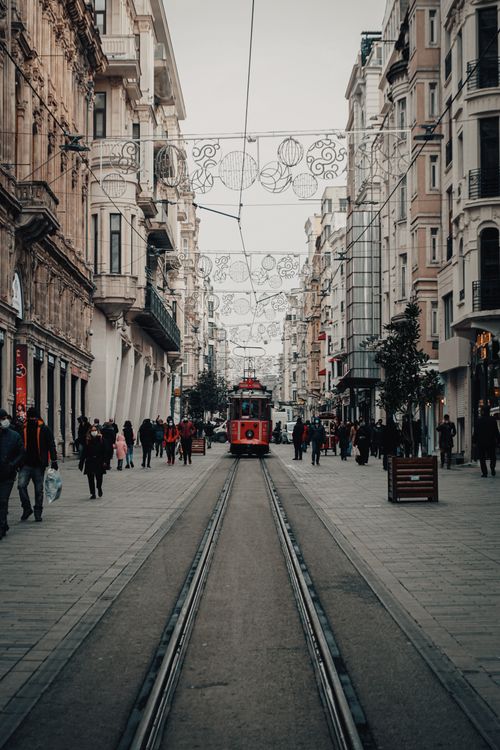 Free Red tram on a bustling Istanbul street adorned with festive decorations, capturing winter city life. Stock Photo