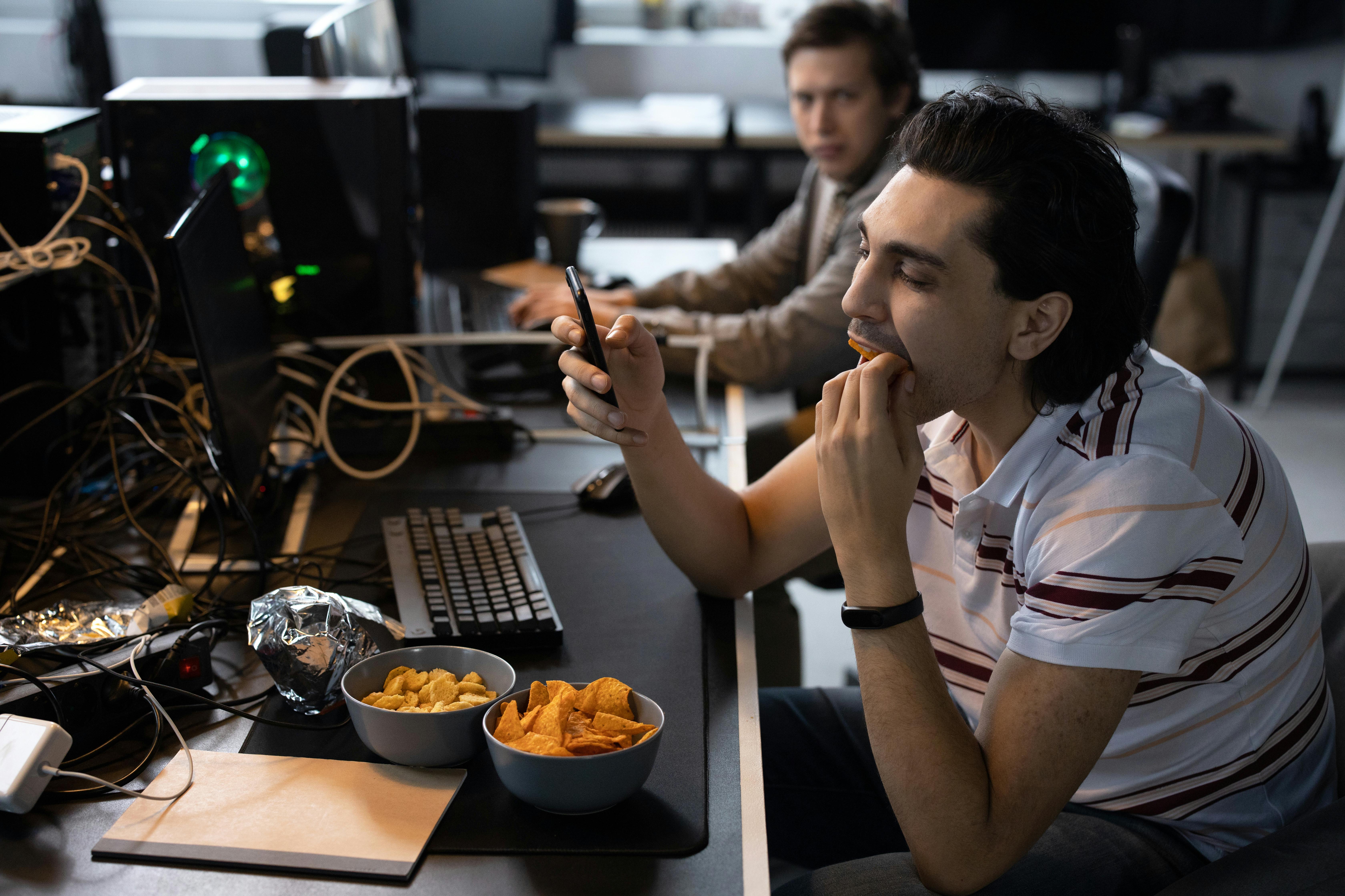 employee eating lunch and texting at a workstation