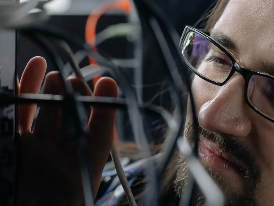 Engineer connecting network cabling for workstations