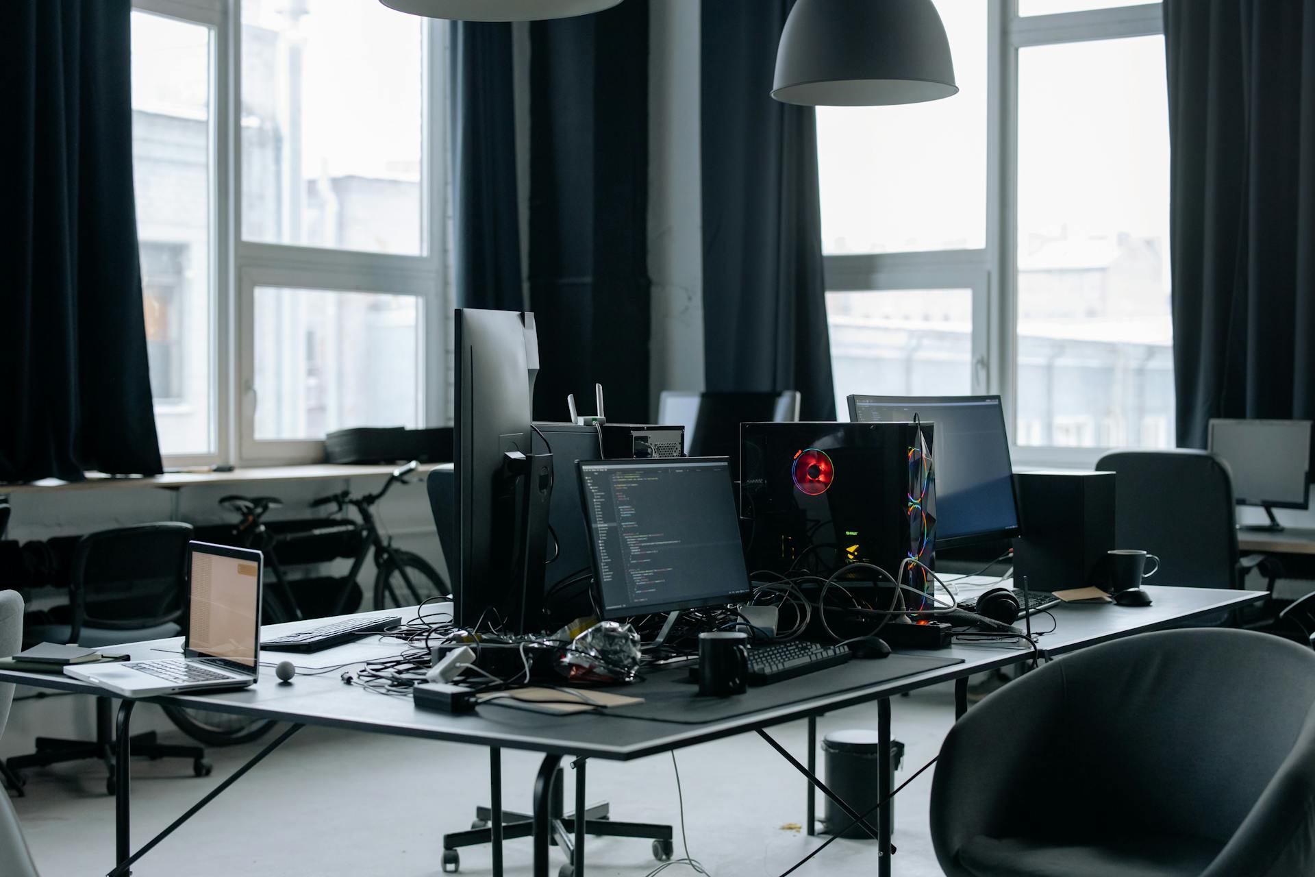 Contemporary workspace featuring computers, coding screens, and office essentials in a tech environment.