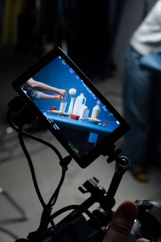 Close-up of a monitor displaying a studio setup for a photography shoot.