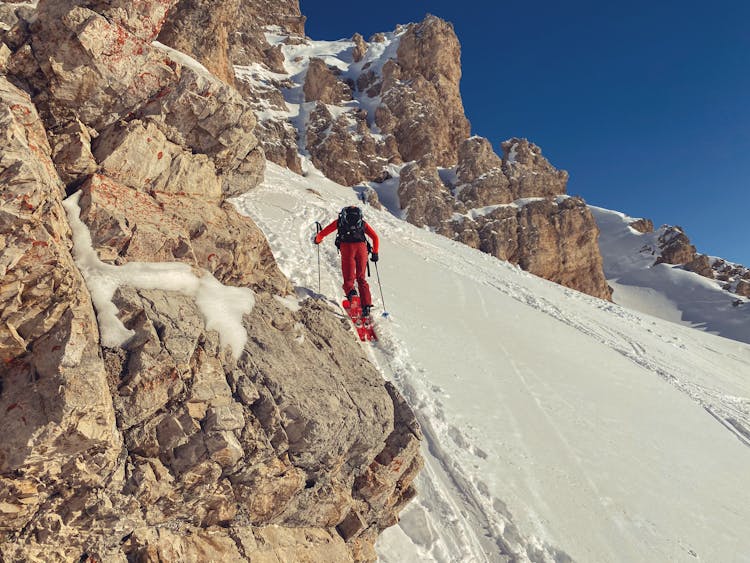 Person Climbing A Mountain In Winter