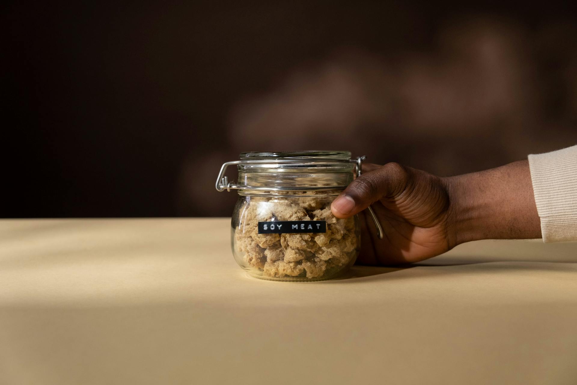 Close-Up Shot of a Person Holding a Jar of Soy Meat