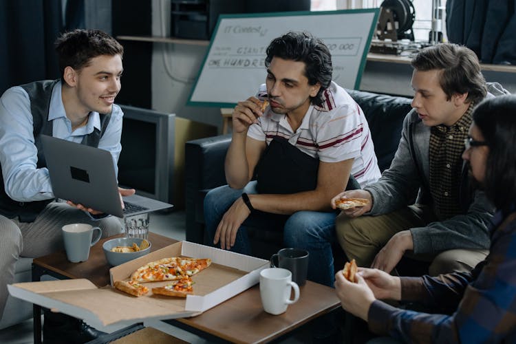 Men Eating Pizza During A Meeting