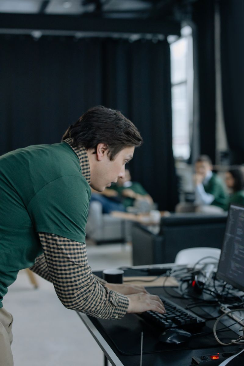 Focused professional typing at a desk in a modern dark office environment