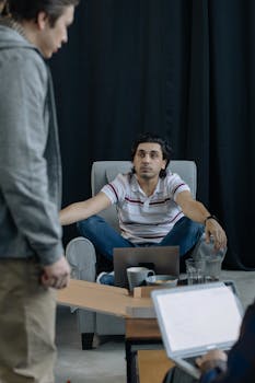 A casual team meeting with men communicating in a modern office setting.