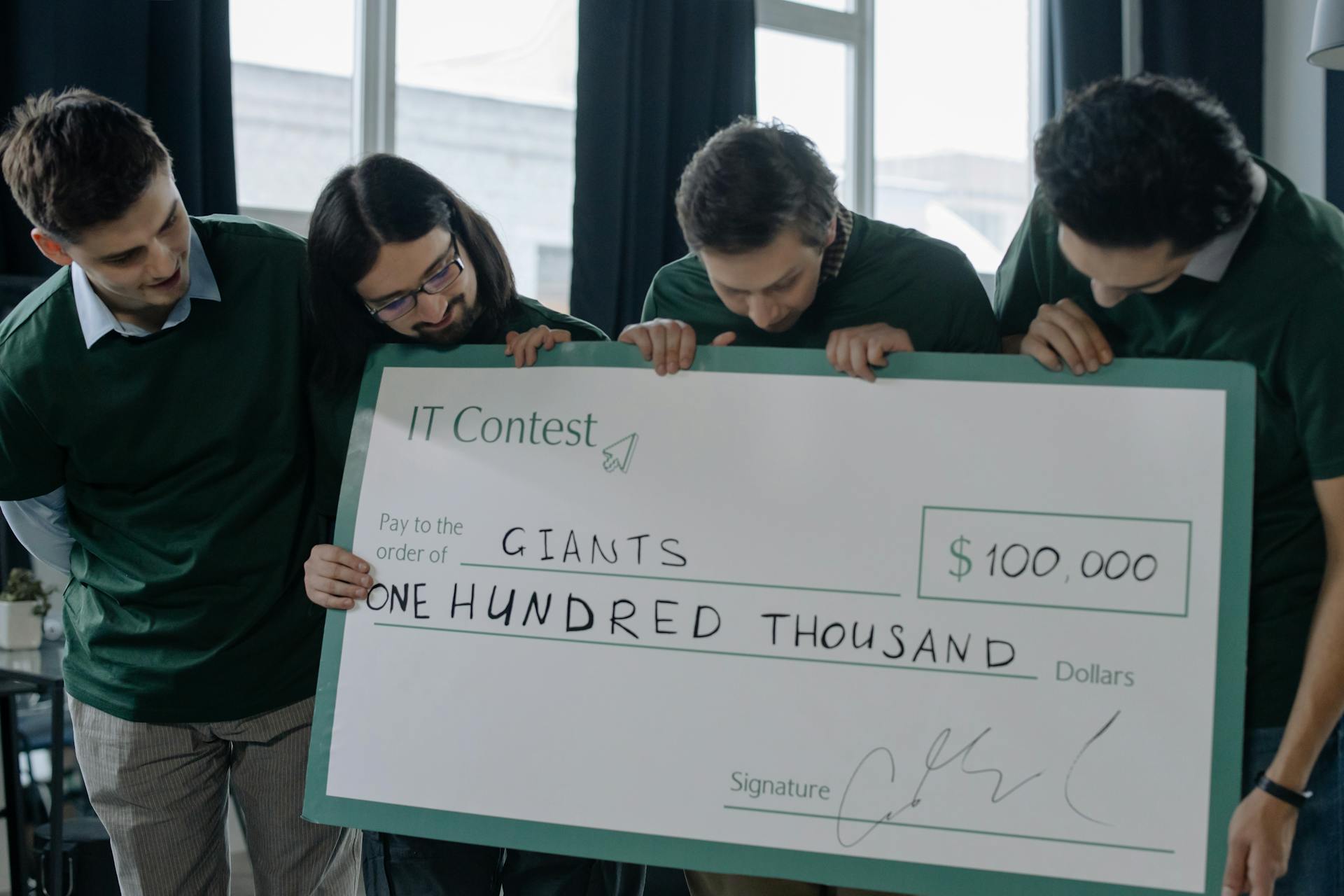 Team Holding a Big Check Happy About Winning Additional Funding