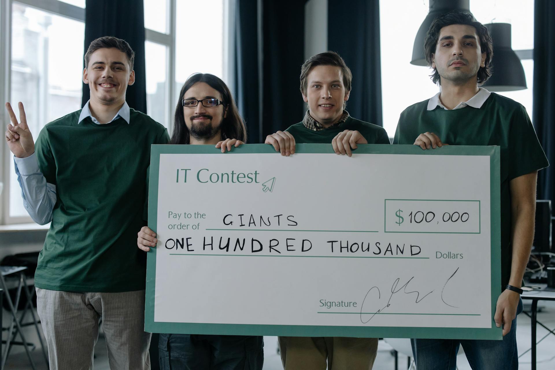 Winning Team of IT Developers Posing with a Huge Cheque Placard