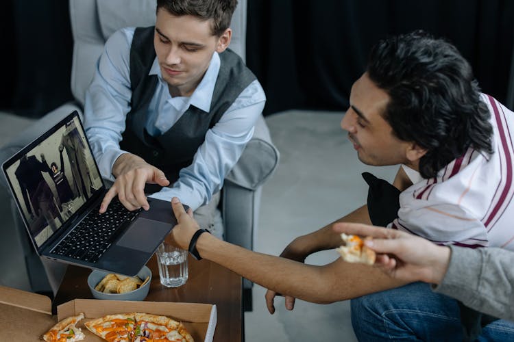 Two Men Looking The Laptop Together 