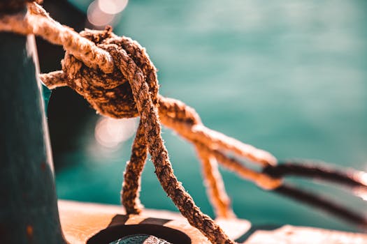Detailed shot of a rope knot aboard a boat in a sunny marina.