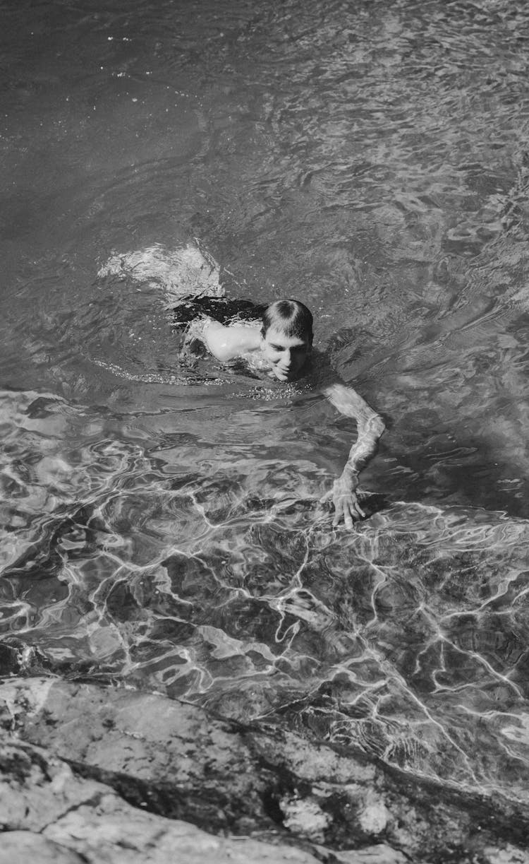 Man Swimming In River In Sunny Day