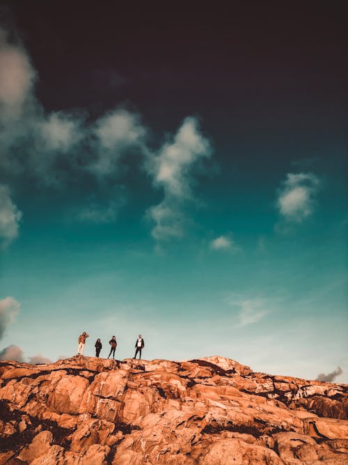 Person Standing on Brown Rock Under Blue Sky