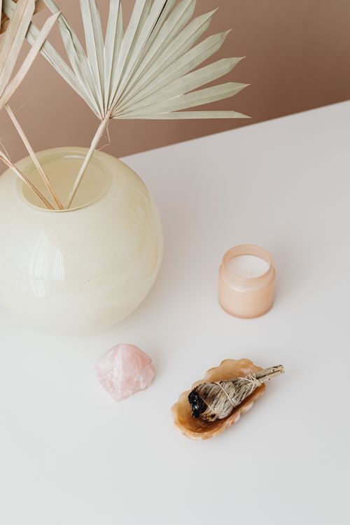 Free A serene minimalist setup featuring dry palm leaves, incense, and candle on a light background. Stock Photo