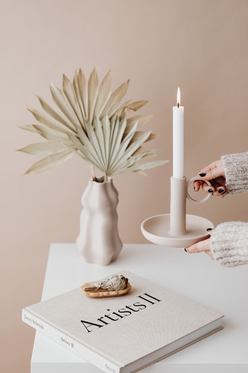 Free Minimalist arrangement with candle, book, and vase on table, perfect for serene interiors. Stock Photo