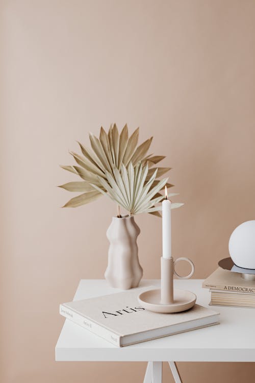 Beige Minimalistic Decor - Dry Palm Leaves in a Vase, Vertical Candle and Books