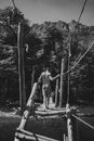 Shirtless male standing on wooden bridge in forest