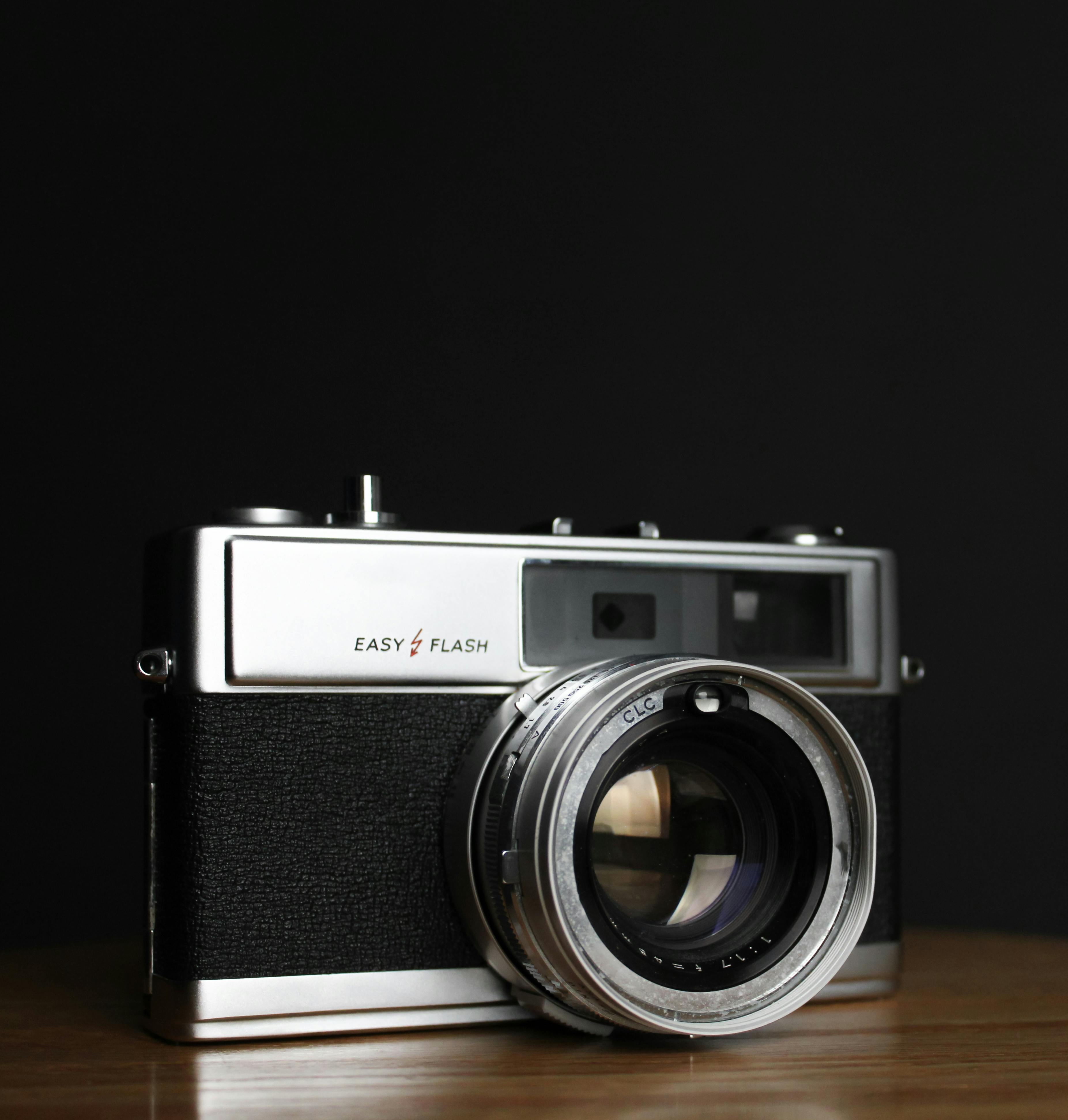 A classic vintage camera with a sleek design on a wooden surface.
