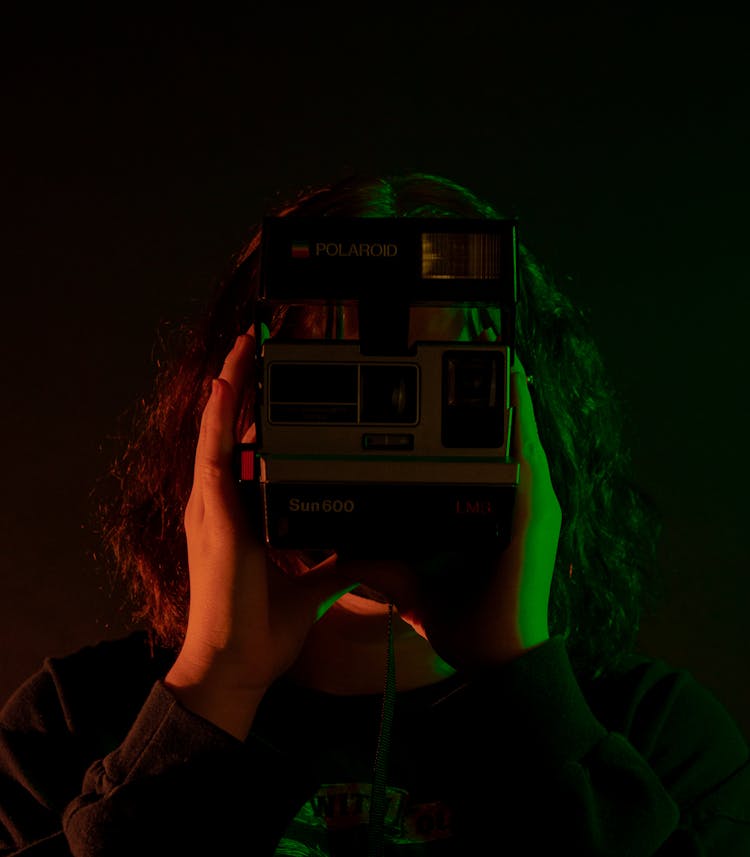 Person Holding Black And Silver Polaroid Camera