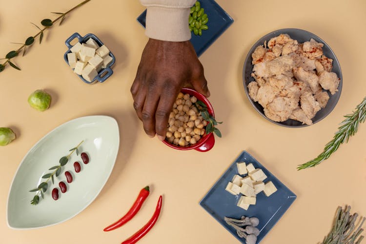 Hand Taking Red Bowl With Beans