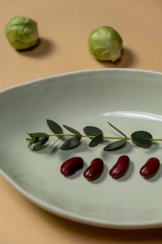 Minimalist display of red beans and greens on a plate with Brussels sprouts.