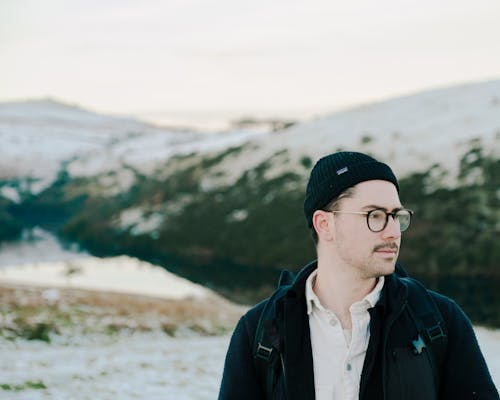 Portrait of a Male Hiker Standing Outdoors With Hill in Background