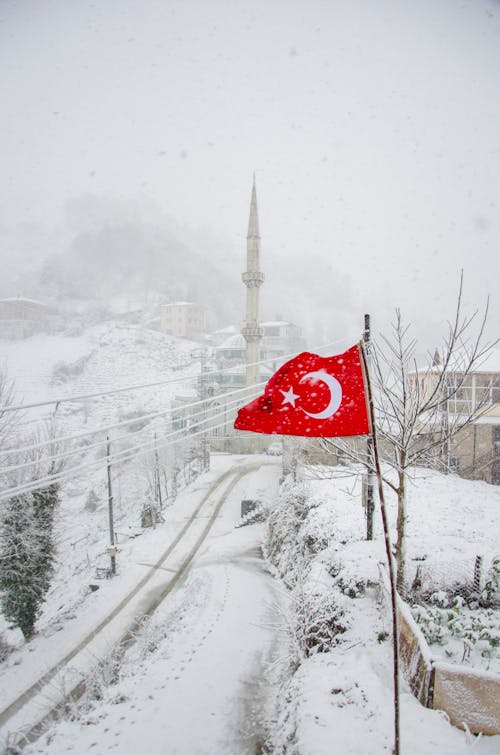 Red and White Flag on Snow Covered Ground