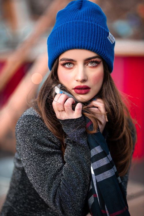 Free Portrait of a woman in a blue beanie, showcasing winter fashion with red lipstick. Stock Photo