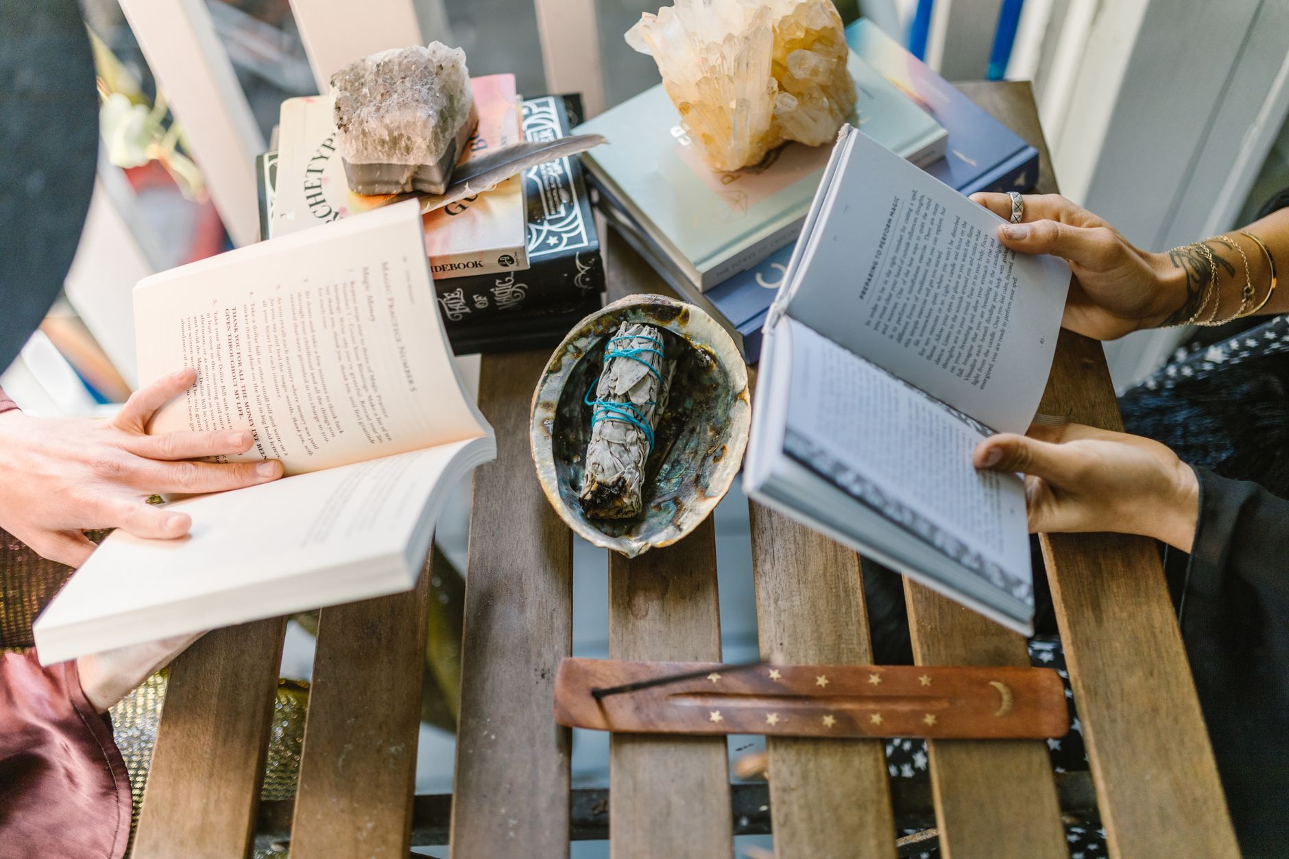 A cozy indoor setup for spiritual reading and crystal healing with books, crystals, and incense.