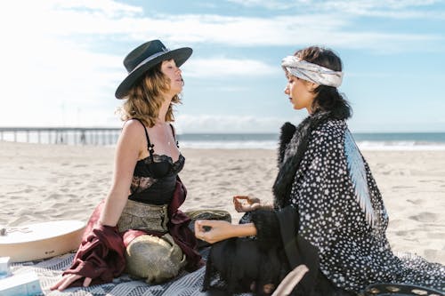 Free Two Women Sitting on the Beach Stock Photo