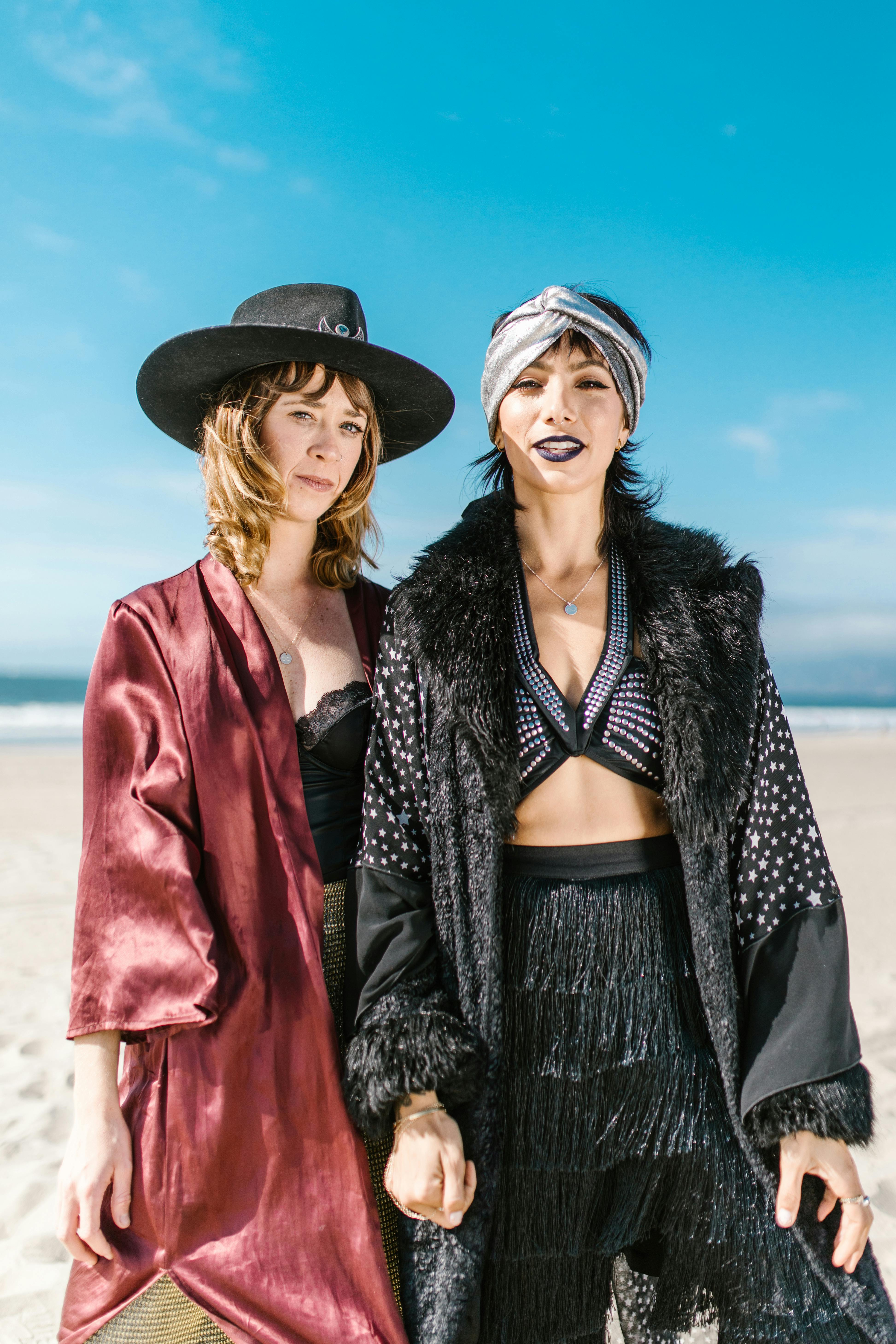 2 women wearing black and red dress and black hat