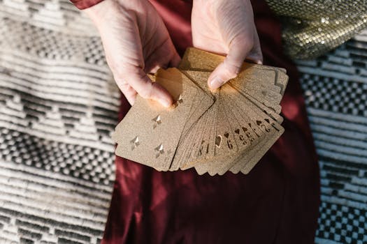 A person holding a fan of golden playing cards, showcasing elegant design and intrigue.