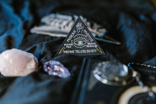 A Triangle Sign Surrounded by Crystals on a Black Surface