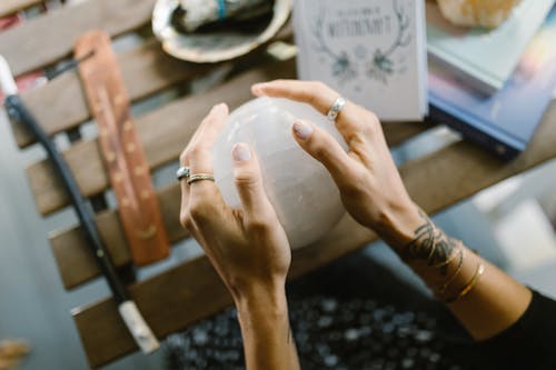 Free Hands Holding the Crystal Ball on the Wooden Table Stock Photo