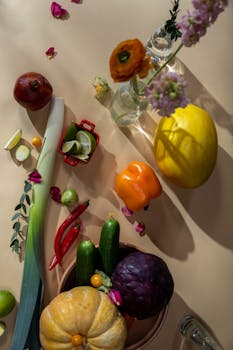 Artistic arrangement of colorful autumn vegetables and flowers in a flat lay composition.