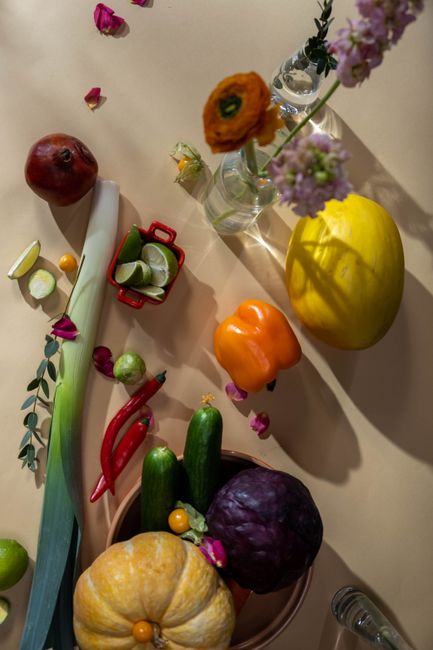 Artistic arrangement of colorful autumn vegetables and flowers in a flat lay composition.