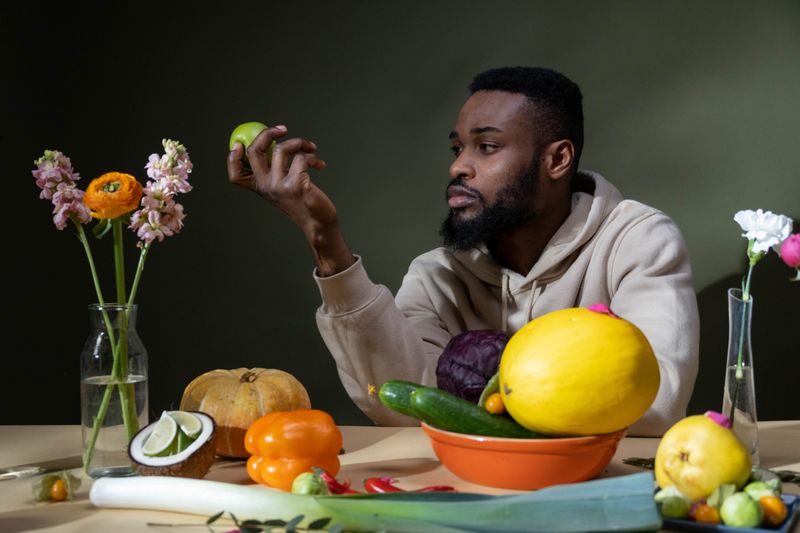 Black African man with fresh fruits and vegetables – gut health and digestive wellness Nigeria