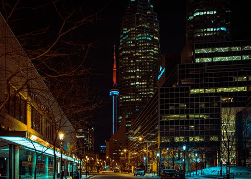 Capture the vibrant cityscape of Toronto at night, featuring the iconic CN Tower.