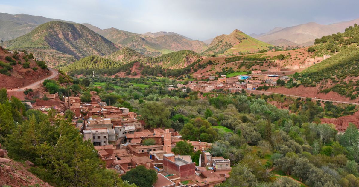 Scenic aerial view of Ait Barka village amidst lush green valleys and rugged mountains.