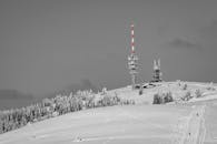 白雪皑皑的山景中，一座通讯塔映衬着宁静的冬日