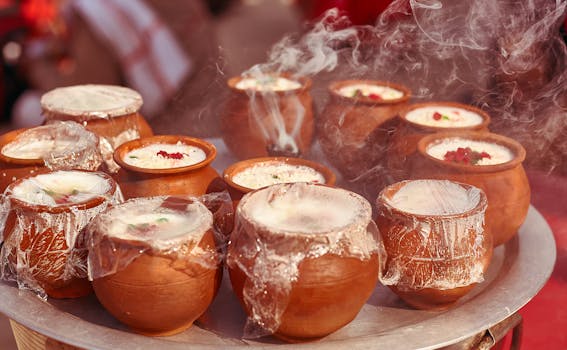 Close-up of steaming Indian desserts in clay pots, infused with aromatic spices and garnished with nuts.