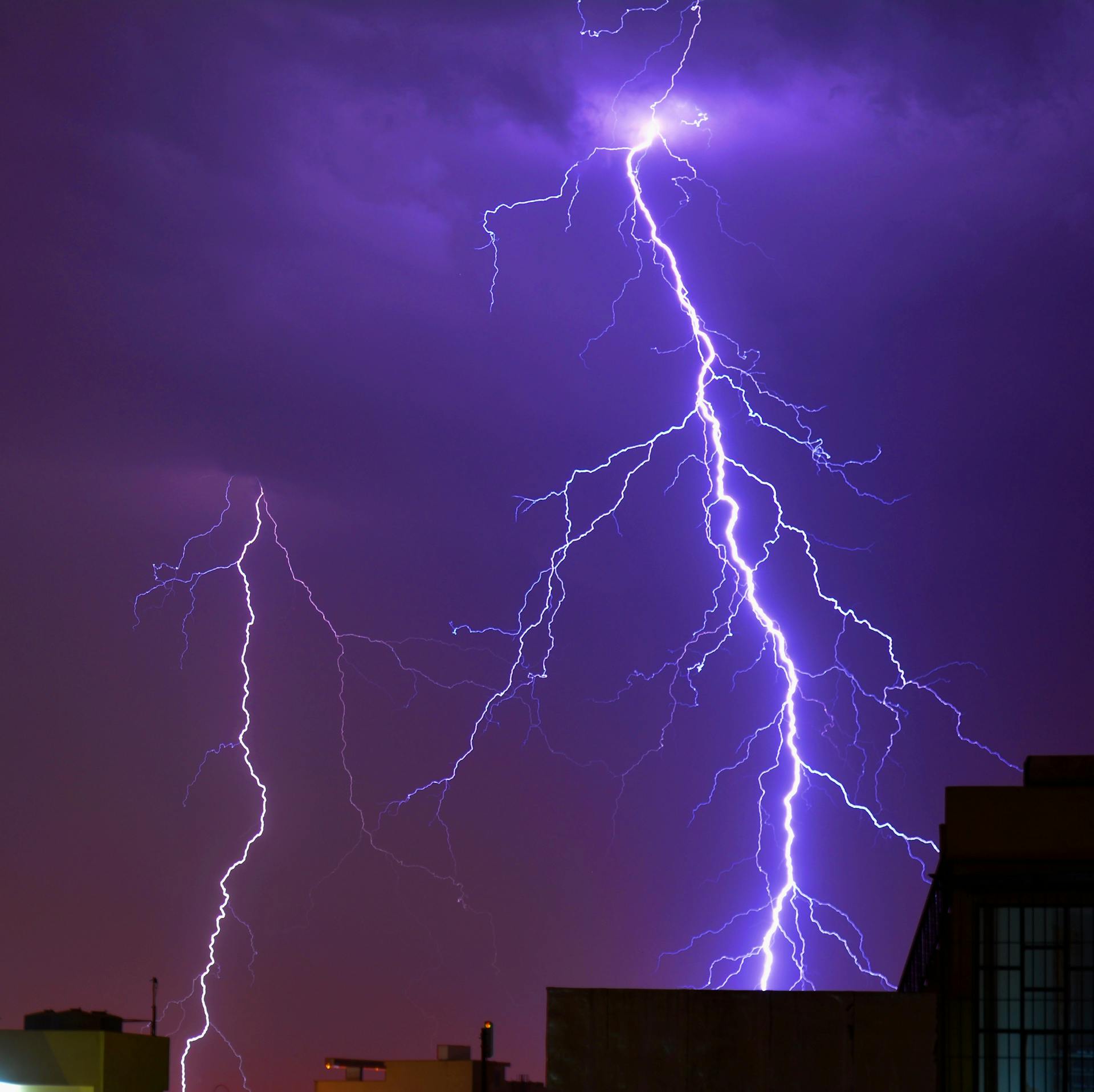 A striking image capturing a powerful lightning bolt illuminating the city skyline at night.