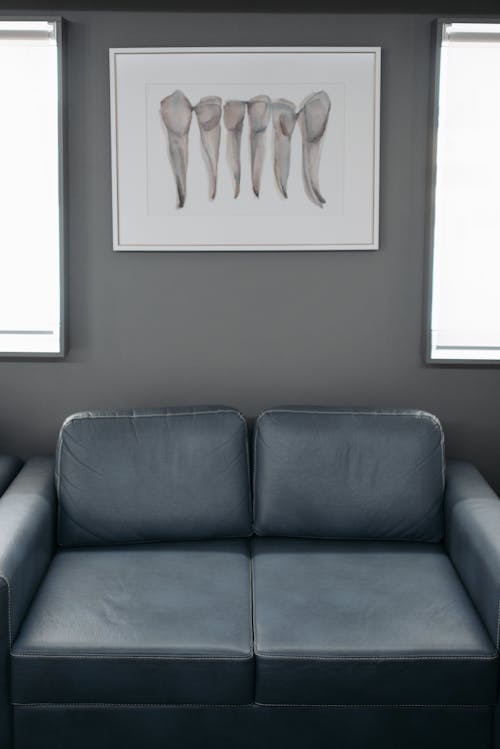 Wall with Painting Behind Gray Leather Couch 