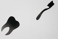Black Paper Cutouts of a Tooth and a Toothbrush