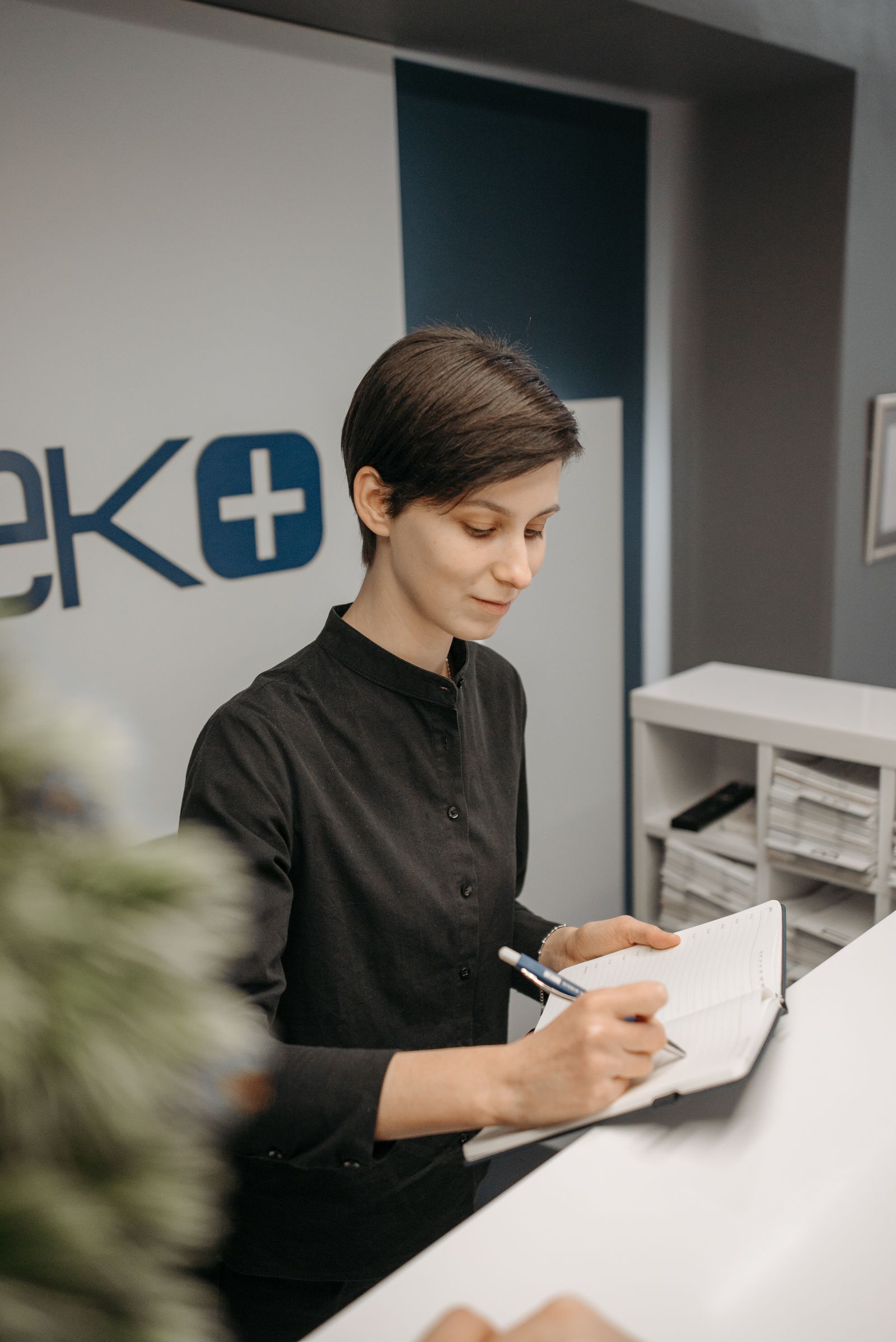 Recepcionista em clínica organizando atendimento e informações de pacientes